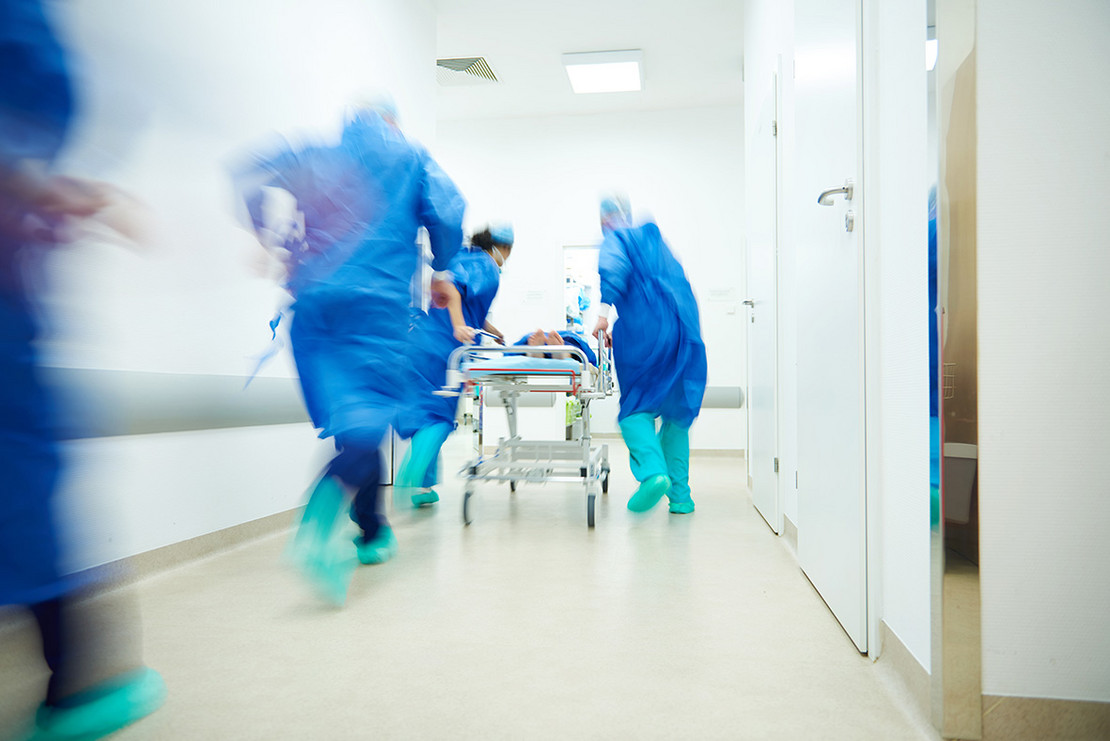 Pflegekräfte laufen durch Gang im Krankenhaus.