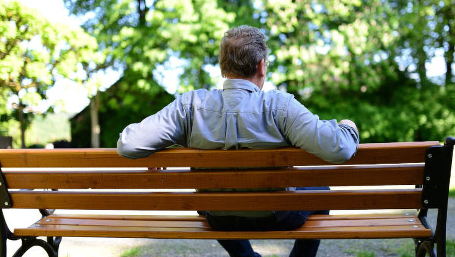 Ein Mann sitzt auf einer Bank